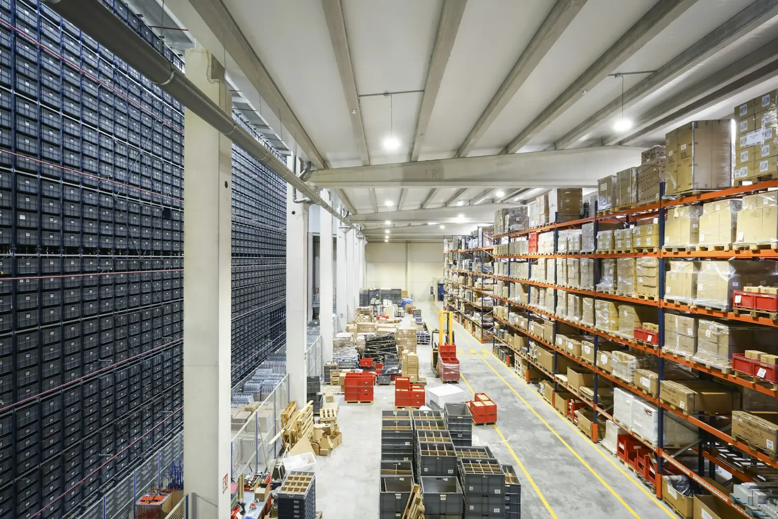 Distribution center with a miniload storage wall beside selective pallet racking